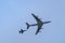 Military tanker aircraft refueler and fighter jets fly on blue sky