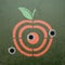 Military target in the form of fruit apple. Metal background wit