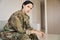 Military woman sits in a bright room