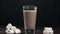 Milk is added to the hot cocoa drink, making the hot cocoa with milk and marshmallows, isolated glass of cocoa