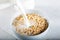 Milk being poured over a bowl of cereal.