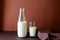 Milk bottle and milk glass on brown paper background.