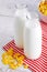 Milk bottles and cereal corn flakes on wooden table