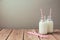 Milk bottles with retro striped straws on wooden table