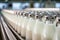 Milk bottling plant: Rows of glass bottles moving on a conveyor in an industrial workshop