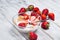 Milk, cereal and strawberries on a wooden table.