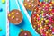 Milk chocolate birthday cake with multicolored glazed candy sprinkles decoration peanut butter cups on blue background. Kids party