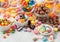 Milk chocolate candies woth shell in jar with various jelly gums candies on white background with liquorice allsorts and