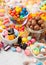 Milk chocolate candies woth shell in jar with various jelly gums candies on white background with liquorice allsorts and