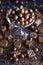 Milk chocolate covered hazelnuts with grated chocolate chips in an elegant bowl, with shaped chocolates