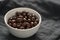 Milk chocolate dragee in white bowl on linen background