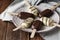 Milk chocolate popsicles on a stick. Ice cream popsicles covered with white and dark chocolate on the plate on wooden background.