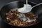 Milk flows on spoon in chocolate muesli, cereals