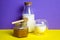 Milk in a glass and a bottle and a jar of honey on a fashionable yellow-purple background.