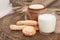 Milk in glass, bread sticks, buns on wooden table.