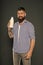 Milk is great for her health. Happy hipster holding bottle of milk on grey background. Bearded man drinking regular milk