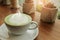 The Milk green tea latte in cup with cactus  on wood table background