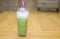 milk green tea in the plastic grass on the table , delicious thing, when we try we can get green tea for good health