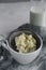 Milk kefir grains in sieve with a bottle of kefir on white table.