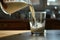 Milk in Motion: An intriguing close-up of milk in motion, as it pours from a clear glass jug into a drinking glass