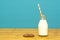 Milk and paper straw in a bottle with a cookie