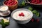 milk porridge with fresh raspberries on a dark background