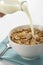 Milk pouring into cereal bowl