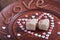 Milk sesame sweets in the shape of heart, on a brown plate with the inscription love