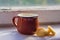 Milk in small mug and kurt standing on windowsill in sunny day