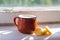 Milk in small mug and kurt standing on windowsill in sunny day