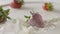 Milk splash on a ripe red strawberry fruit, which lies on a white plate with milk. Slow motion. A few berries lie on the