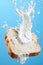 Milk splash on sliced bread against blue background AI Generated