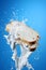 Milk splash on sliced bread against blue background AI Generated