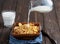 Milk splash on wooden bowl with a cereal corn flakes. Dark wooden backgraund, close up. Shallow depth of field
