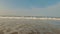 Milk white colored waves hitting on the beach of Konkan with cloudy sky in the background.