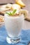 milkshake with banana, granola and cinnamon in a glass, vertical