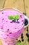 Milkshake with blueberries in glass on wooden board