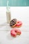 Milkshake in glass bottle with sweet donuts on the table