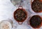 Milkshake and pots of roasted coffee beans and anise seeds on white surface