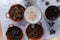 Milkshake and pots of roasted coffee beans and anise seeds on white surface