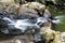 Milky flowing waters and rocks of waterfall