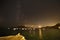 Milky Way, full moon and reflections in the sea at the pier of Isleta del Moro, Almeria, Spain