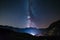 The Milky way galaxy and stars over the Italian French Alps. Night sky on majestic snowcapped mountains and glaciers. Meteor