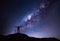 Milky Way landscape. Silhouette of Happy man standing on top of mountain with night sky and bright star on background