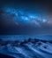 Milky way over frozen beach in winter at night