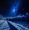 Milky way over frozen railway line in winter at night
