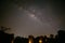 Milky way rising up parallel with ancient stone cliff