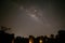 Milky way rising up parallel with ancient stone cliff