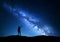 Milky Way. Silhouette of a standing man pointing finger in night starry sky on the mountain