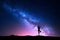 Milky Way with silhouette of a standing woman practicing yoga